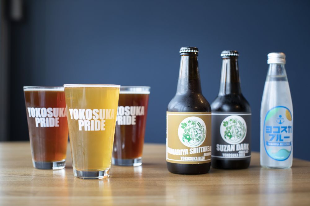 YOKOSUKA BEERのクラフトビール商品。「YOKOSUKA PRIDE」のグラスに注がれた3種類のビール。グラス、ボトル、が並んでいる。