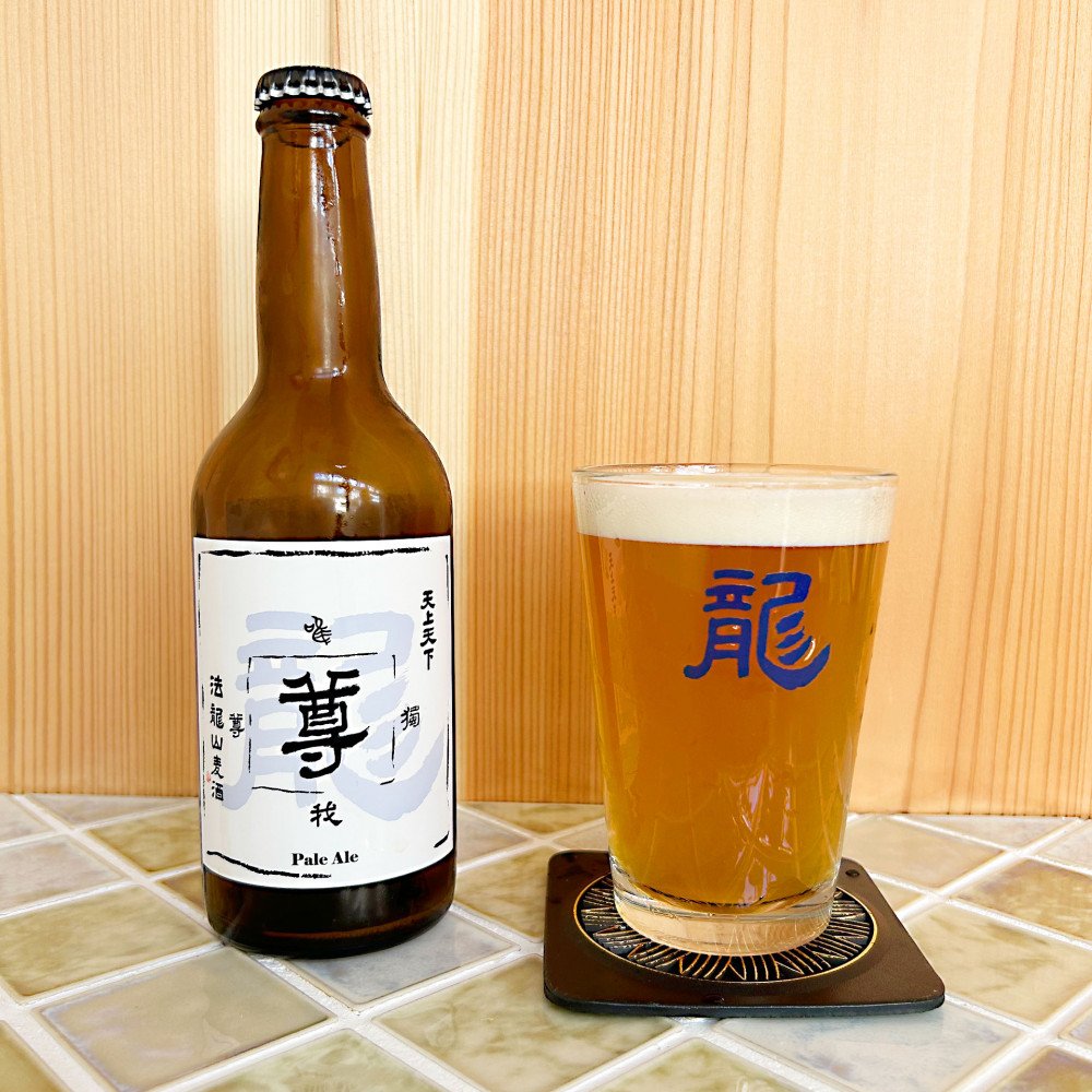 法龍山ブルワリーの「Son Pale Ale」ボトルとグラス。木製の背景。